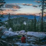 PCT thru-hiker looking at the view during sunset near South Lake Tahoe